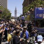 
              Stephen Curry and Damion Lee, right, ride atop a bus during the Golden State Warriors NBA championship parade in San Francisco, Monday, June 20, 2022. (AP Photo/Eric Risberg)
            
