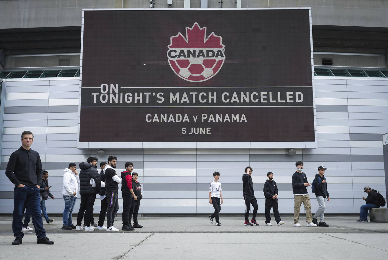 Fans gather outside B.C. Place stadium after the Canadian national men's soccer team's match agains...