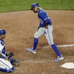 
              Toronto Blue Jays' Raimel Tapia heads to the dugout past Kansas City Royals catcher Salvador Perez after scoring when Bo Bichette was walked by relief pitcher Dylan Coleman during the seventh inning of a baseball game Tuesday, June 7, 2022, in Kansas City, Mo. (AP Photo/Charlie Riedel)
            