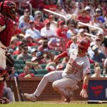 
              Cincinnati Reds' Kyle Farmer (17) scores past St. Louis Cardinals catcher Yadier Molina during the eighth inning of a baseball game Saturday, June 11, 2022, in St. Louis. (AP Photo/Jeff Roberson)
            