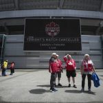
              Fans stand outside B.C. Place stadium after the Canadian national men's soccer team's friendly match against Panama was canceled due to a labor dispute, in Vancouver, British Columbia, Sunday, June 5, 2022. (Darryl Dyck/The Canadian Press via AP)
            