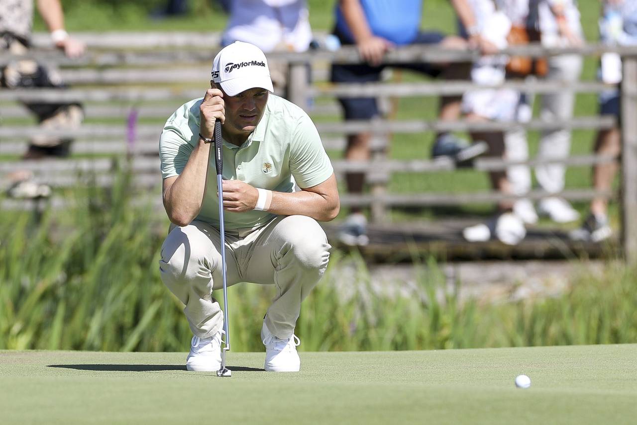 Germany's Martin Kaymer squats on the green during the German International Open golf tournament at...