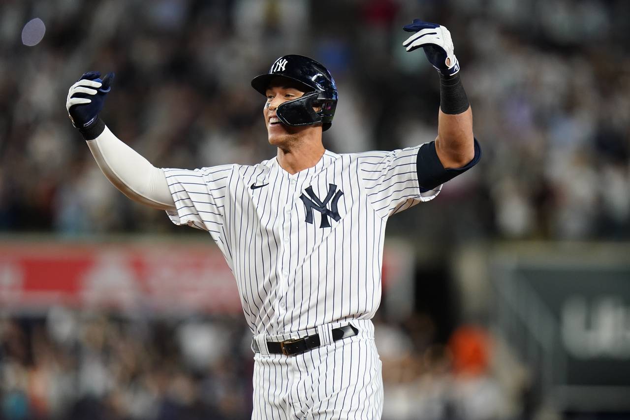 New York Yankees' Aaron Judge gestures to teammates after hitting a single to drive in the winning ...