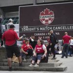 
              Fans sit and gather outside B.C. Place stadium after the Canadian national men's soccer team's friendly match against Panama was canceled due to a labor dispute, in Vancouver, British Columbia, Sunday, June 5, 2022. (Darryl Dyck/The Canadian Press via AP)
            