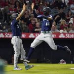 Seattle Mariners' Julio Rodriguez, right, celebrates with J.P. Crawford after they scored on a single by Kevin Padlo during the sixth inning of a baseball game Saturday, June 25, 2022, in Anaheim, Calif. (AP Photo/Mark J. Terrill)