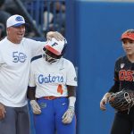 
              Florida coach Billy Napier and Charla Echols (4) celebrate after she reached third base during the fifth inning of an NCAA softball Women's College World Series game against Oregon State on Thursday, June 2, 2022, in Oklahoma City. (AP Photo/Alonzo Adams)
            
