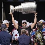 
              Colorado Avalanche president and governor Josh Kroenke lifts the Stanley Cup during a rally outside the City/County Building for the NHL hockey champions after a parade through the streets of downtown Denver, Thursday, June 30, 2022. (AP Photo/David Zalubowski)
            