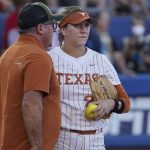 
              Texas starting pitcher Hailey Dolcini, right, is taken out of the game by coach Mike White, left, during the first inning against Oklahoma in the first game of the NCAA Women's College World Series softball championship series Wednesday, June 8, 2022, in Oklahoma City. (AP Photo/Sue Ogrocki)
            