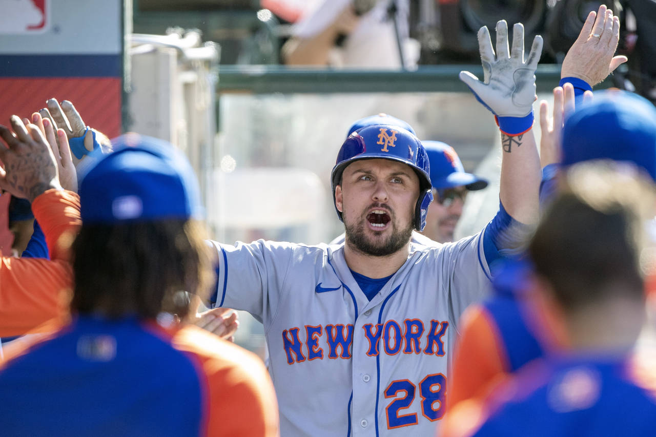 New York Mets designated hitter J.D. Davis, center, reacts as he is congratulated in the dugout aft...