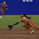 
              Texas' Janae Jefferson dives for a ball hit by Oklahoma's Rylie Boone for a single during the sixth inning of the second game of the NCAA Women's College World Series softball championship series Thursday, June 9, 2022, in Oklahoma City. (AP Photo/Sue Ogrocki)
            