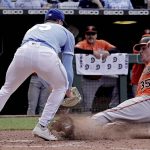 
              Baltimore Orioles' Adley Rutschman (35) beats the tag by Kansas City Royals relief pitcher Dylan Coleman to score on Coleman's wild pitch during the eighth inning of a baseball game Saturday, June 11, 2022, in Kansas City, Mo. (AP Photo/Charlie Riedel)
            