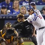 
              Los Angeles Dodgers' Justin Turner, right, hits a two-run home run as San Diego Padres catcher Austin Nola, left, watches along with home plate umpire Dan Iassogna during the seventh inning of a baseball game Thursday, June 30, 2022, in Los Angeles. (AP Photo/Mark J. Terrill)
            