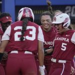 
              Oklahoma's Taylon Snow (5) is greeted at the plate after hitting a home run against Texas during the first inning of the first game of the NCAA Women's College World Series softball championship series Wednesday, June 8, 2022, in Oklahoma City. (AP Photo/Sue Ogrocki)
            
