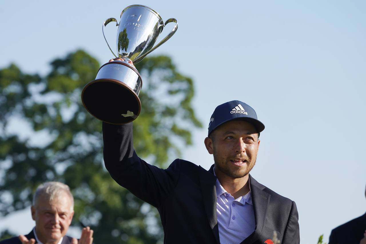 Xander Schauffele holds the trophy after winning the Travelers Championship golf tournament at TPC ...