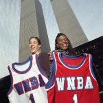 
              FILE - Olympic gold medalists Rebecca Lobo, left, of Southwick, Mass., and Sheryl Swoopes, of Lubbock, Texas, display their jerseys for the inaugural season of the Women's National Basketball Association in the shadow of New York's World Trade Center, Oct. 23, 1996. (AP Photo/Richard Drew, File)
            