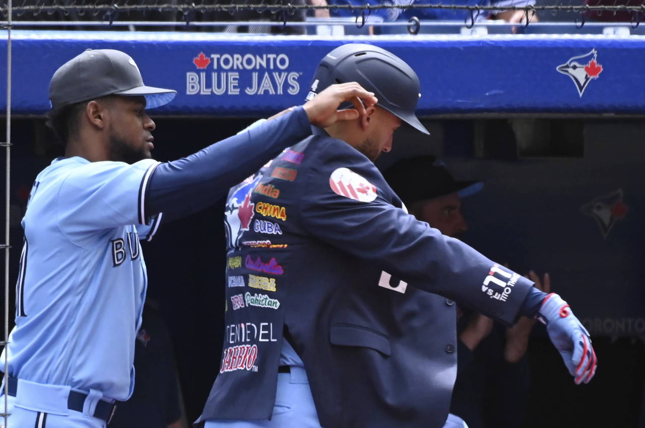 Toronto Blue Jays center-fielder George Springer, right, receives the home run jacket from Otto Lop...