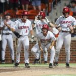 
              Arkansas' Chris Lanzilli (18), Robert Moore (1) and  Michael Turner (12) yell in celebration as Jalen Battles heads for home after hitting a grand slam against Oklahoma State during an NCAA college baseball tournament regional game Saturday, June 4, 2022, in Stillwater, Okla. (Ian Maule/Tulsa World via AP)
            