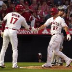Los Angeles Angels' Mike Trout, center, is congratulated by Shohei Ohtani, left, after hitting a solo home run as Seattle Mariners catcher Cal Raleigh stands at the plate during the fourth inning of a baseball game Friday, June 24, 2022, in Anaheim, Calif. (AP Photo/Mark J. Terrill)