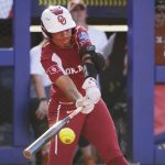 
              Oklahoma's Tiare Jennings hits a single against Texas during the first inning of the second game of the NCAA softball Women's College World Series finals Thursday, June 9, 2022, in Oklahoma City. (AP Photo/Sue Ogrocki)
            