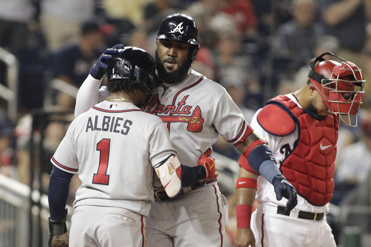 Atlanta Braves' Marcell Ozuna, right, celebrates with teammate Ozzie Albies (1) after hitting a two...