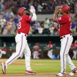 
              Texas Rangers' Adolis Garcia, left, and third base coach Tony Beasley, right, celebrate after Garcia hit a solo home run in the sixth inning of a baseball game against the Washington Nationals, Friday, June 24, 2022, in Arlington, Texas. (AP Photo/Tony Gutierrez)
            