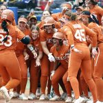 
              Texas catcher Mary Iakopo (33) is greeted by her team at home plate after hitting a home run in the third inning of an NCAA softball Women's College World Series game against UCLA on Thursday, June 2, 2022, in Oklahoma City. (AP Photo/Alonzo Adams)
            