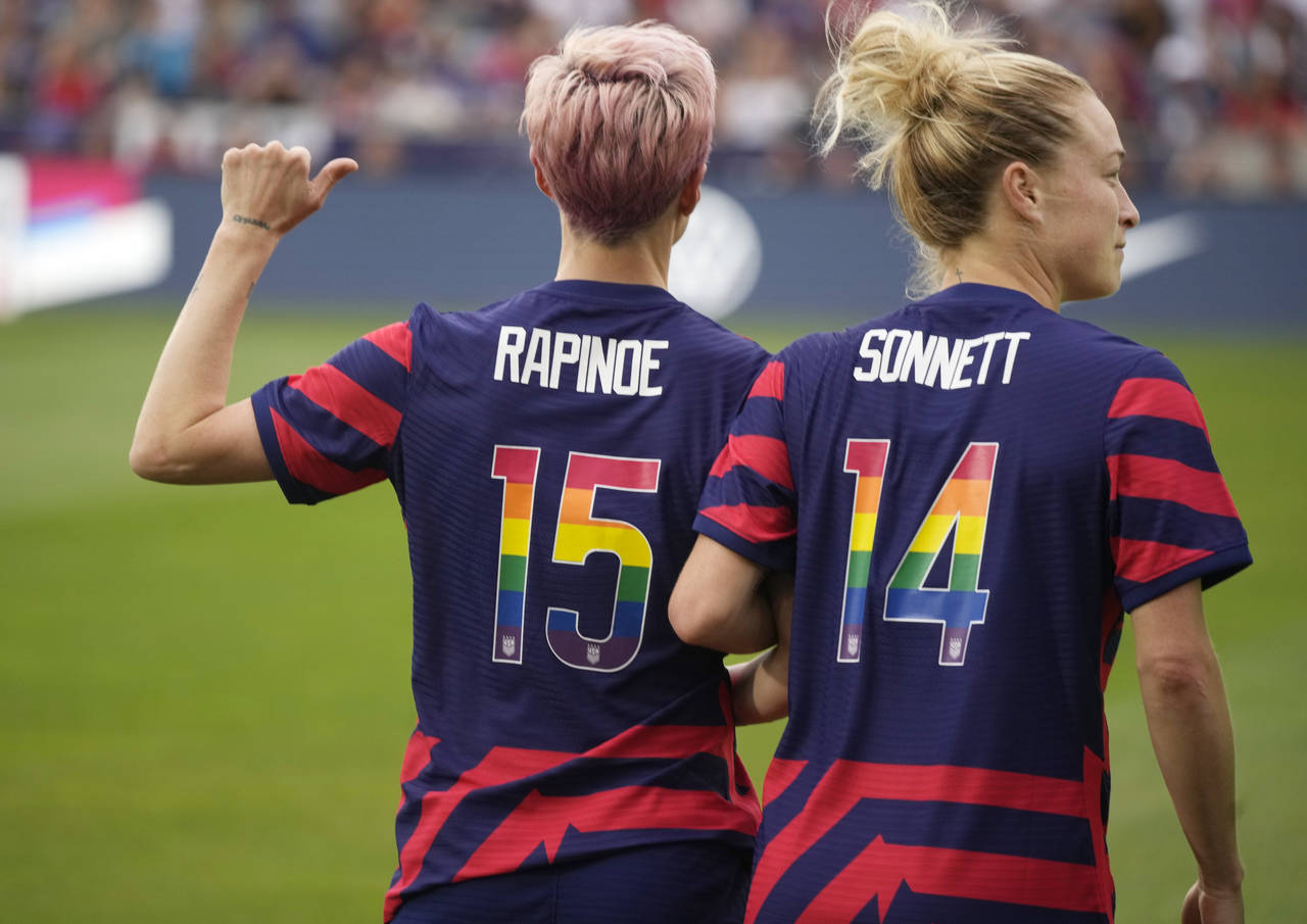 U.S. forward Megan Rapinoe,left, and defender Emily Sonnett line up with teammates for a team photo...
