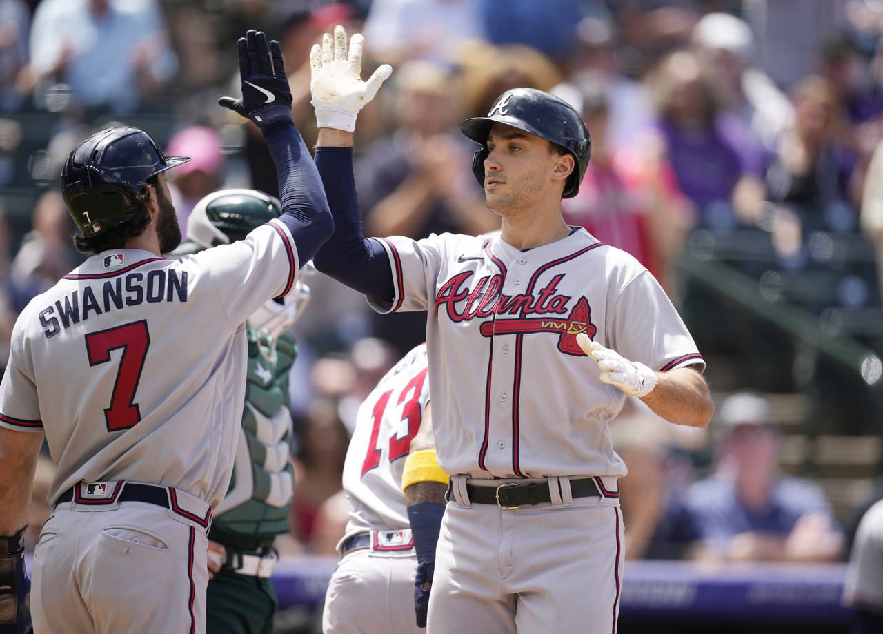 Atlanta Braves' Dansby Swanson, left, congratulates Matt Olson who crosses home plate after hitting...