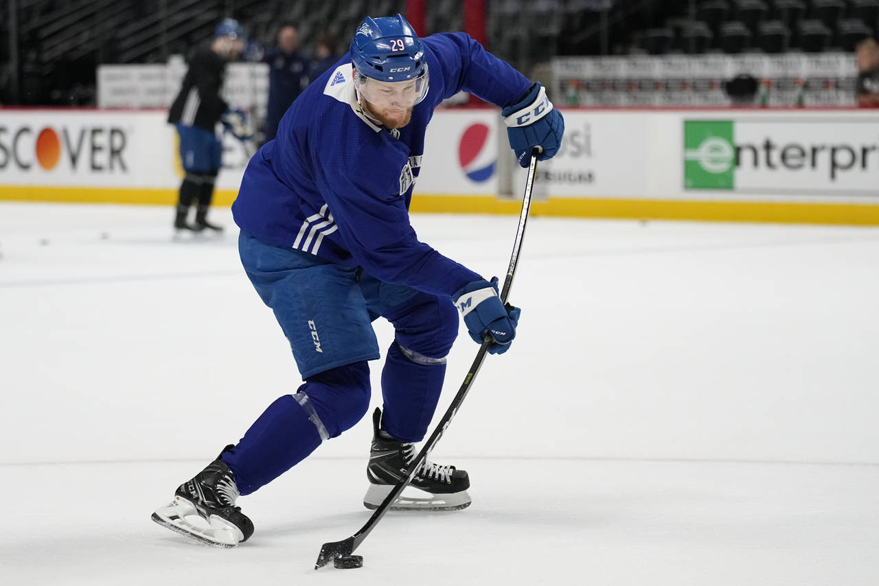 Colorado Avalanche center Nathan MacKinnon (29) hits a shot during an NHL hockey practice, ahead of...