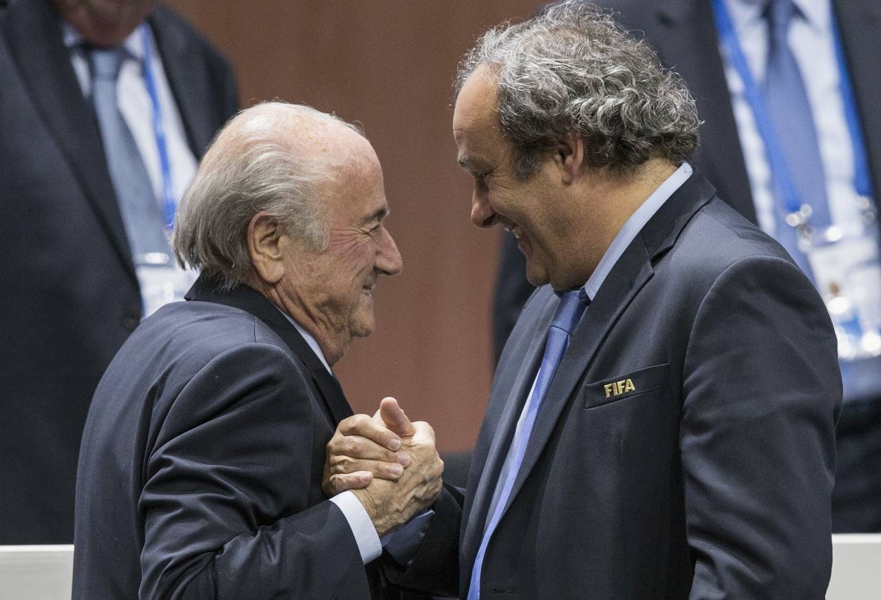 FILE - FIFA president Sepp Blatter is greeted by UEFA President Michel Platini, right, after Blatte...