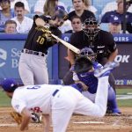 
              Pittsburgh Pirates' Bryan Reynolds, upper left, hits a two-run home run as Los Angeles Dodgers starting pitcher Mitch White, below, watches along with catcher Austin Barnes and home plate umpire Chad Fairchild during the fifth inning of a baseball game Wednesday, June 1, 2022, in Los Angeles. (AP Photo/Mark J. Terrill)
            