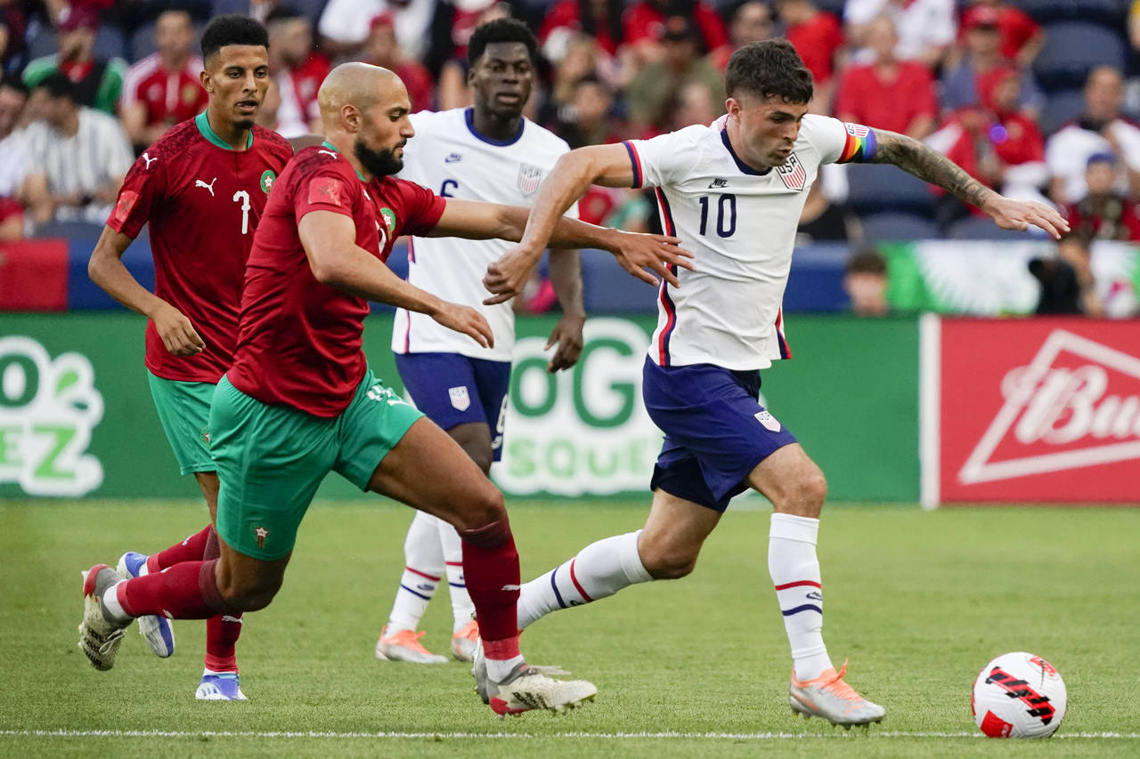 U.S. forward Christian Pulisic (10) dribbles past Morocco's Sofyan Amrabat, front left, during the ...