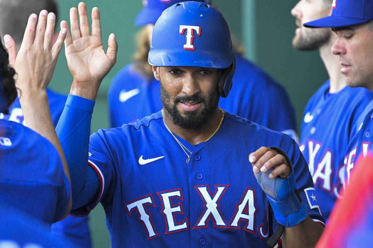 Texas Rangers' Marcus Semien is congratulated after scoring against the Kansas City Royals during t...