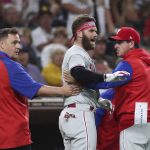 
              Philadelphia Phillies' Bryce Harper, center, reacts towards San Diego Padres pitcher Blake Snell after being hit by a pitch, as he walks off the field with interim manager Rob Thomson, right, and a trainer during the fourth inning of a baseball game Saturday, June 25, 2022, in San Diego. (AP Photo/Derrick Tuskan)
            
