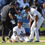 
              New York Yankees second baseman Gleyber Torres, bottom, reacts after an ankle injury during the ninth inning of a baseball game against the Houston Astros, Sunday, June 26, 2022, in New York. At right is New York Yankees third base coach Luis Rojas. (AP Photo/Noah K. Murray)
            