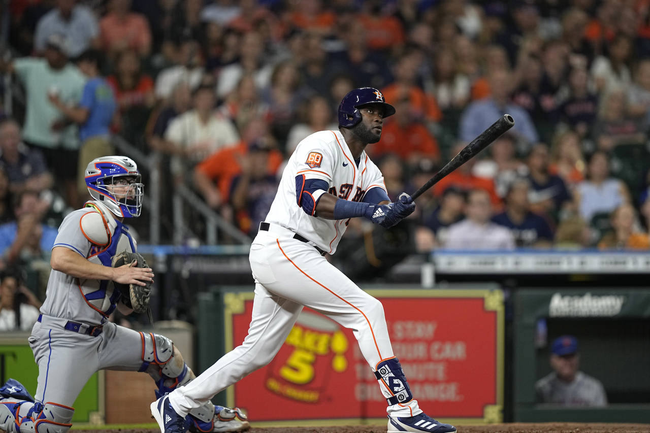 Houston Astros' Yordan Alvarez, right, watches his two-run home run along with New York Mets catche...