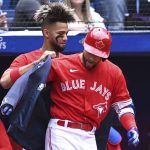 
              Toronto Blue Jays' Lourdes Gurriel Jr., center left, puts the home run jacket on George Springer, center right, after Springer hit a solo home run against the Minnesota Twins in the first inning of a baseball game in Toronto, Sunday, June 5, 2022. (Jon Blacker/The Canadian Press via AP)
            