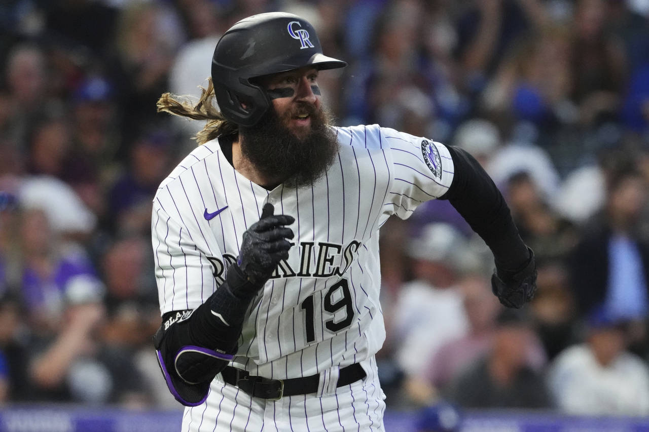 Colorado Rockies' Charlie Blackmon runs to first on a double against the Los Angeles Dodgers during...