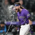
              Colorado Rockies' Brendan Rodgers is hit by a stream of water from a teammate as he circles the bases after hitting a two-run home run off Miami Marlins relief pitcher Cole Sulser during the 10th inning of the second game of a baseball doubleheader Wednesday, June 1, 2022, in Denver. (AP Photo/David Zalubowski)
            