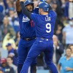 
              Los Angeles Dodgers' Hanser Alberto, left, celebrates with Gavin Lux after they and Cody Bellinger scored on double by Mookie Betts against the New York Mets during the second inning of a baseball game in Los Angeles, Saturday, June 4, 2022. (AP Photo/Alex Gallardo)
            