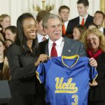 
              FILE - President Bush holds a jersey with UCLA  women's softball captain Natasha Watley as the team as he met with the reigning NCAA champions in several sports, in the East Room event at the White House in Washington, Monday, Nov. 17, 2003. Fifty years after the passage of Title IX, racial disparities still exist for women in college athletics. (AP Photo/J. Scott Applewhite, File)
            