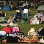 
              A person sleeps in the queue before the start of day one of the Wimbledon tennis championships in London, Monday, June 27, 2022. (Aaron Chown/PA via AP)
            