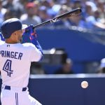 
              Toronto Blue Jays' center fielder George Springer (4) hits a check swing single that scored Lourdes Gurriel Jr during the second inning of a baseball game against the Minnesota Twins, Saturday, June 4, 2022 in Toronto. (Jon Blacker/The Canadian Press via AP)
            