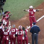 
              Oklahoma players cheer Jocelyn Alo (78), who approaches home after hitting a home run against Texas during Game 1 of the NCAA Women's College World Series championships in Oklahoma City on Wednesday, June 8, 2022. (Ian Maule/Tulsa World via AP)
            