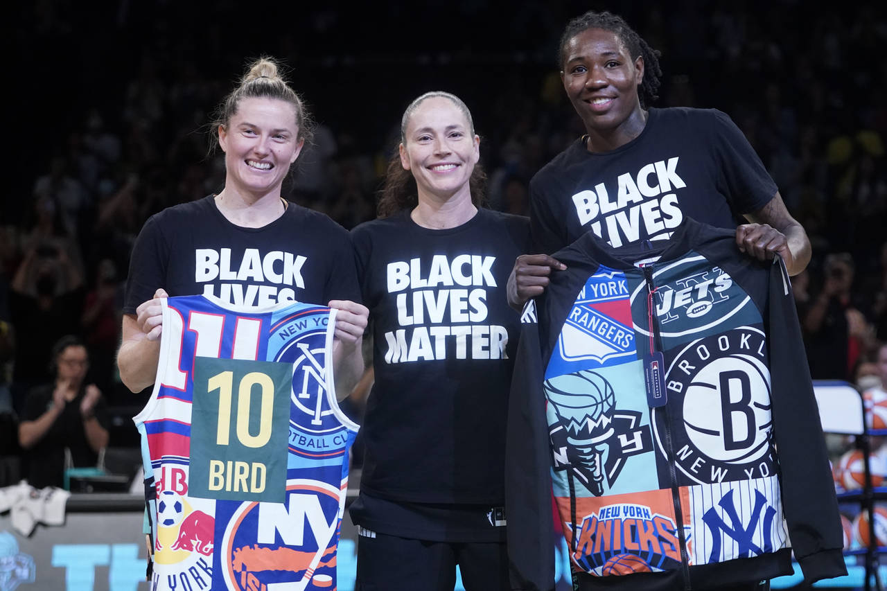 Seattle Storm guard Sue Bird, center, poses for a photo with former Storm teammates, New York Liber...
