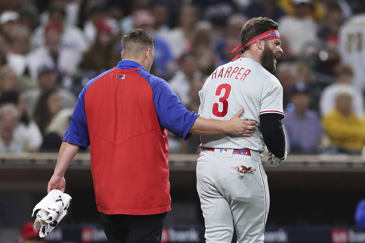 Philadelphia Phillies' Bryce Harper, right, reacts towards San Diego Padres' Blake Snell after bein...