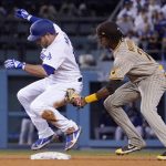 
              Los Angeles Dodgers' Max Muncy, left, is tagged out by San Diego Padres shortstop C.J. Abrams as he pops off the base after sliding in for a double during the fourth inning of a baseball game Thursday, June 30, 2022, in Los Angeles. (AP Photo/Mark J. Terrill)
            