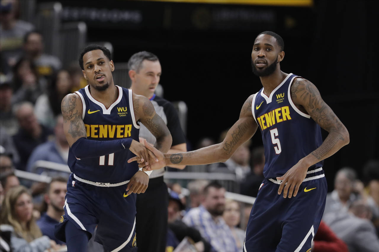 FILE - Denver Nuggets' Monte Morris (11) and Will Barton (5) react during the second half of an NBA...