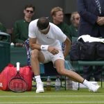 
              Bulgaria's Grigor Dimitrov sits down after an injury during the singles tennis match against Steve Johnson of the US on day two of the Wimbledon tennis championships in London, Tuesday, June 28, 2022. (AP Photo/Alastair Grant)
            