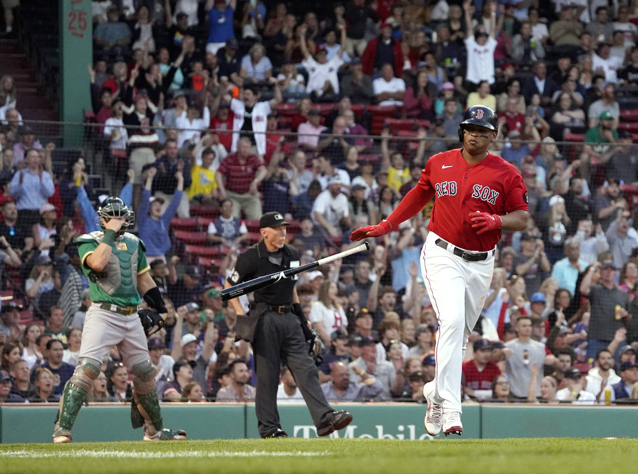 Boston Red Sox's Rafael Devers tosses his bat after hitting a two-run home run, as Oakland Athletic...
